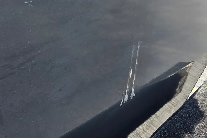 Slide: The Image of 2021 Ranger VS1882 WT boat hull with visible scratches on dark surface. - 27