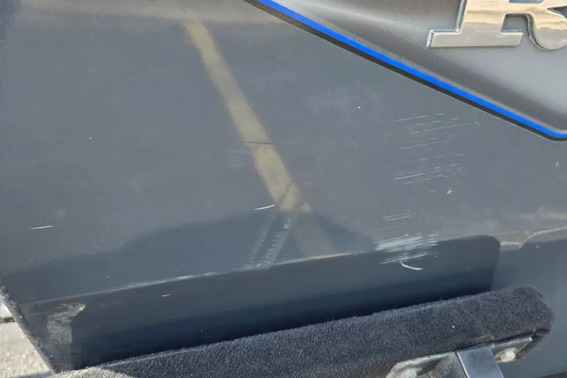 Slide: The Image of 2021 Ranger VS1882 WT boat with visible scratches on the dark exterior surface. - 32