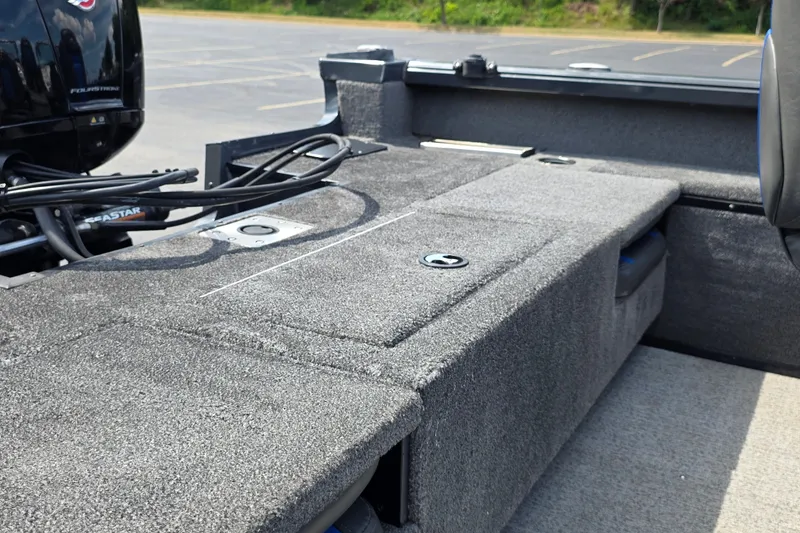 Slide: The Image of 2021 Ranger VS1882 WT boat interior with carpeted deck and motor cables. - 17