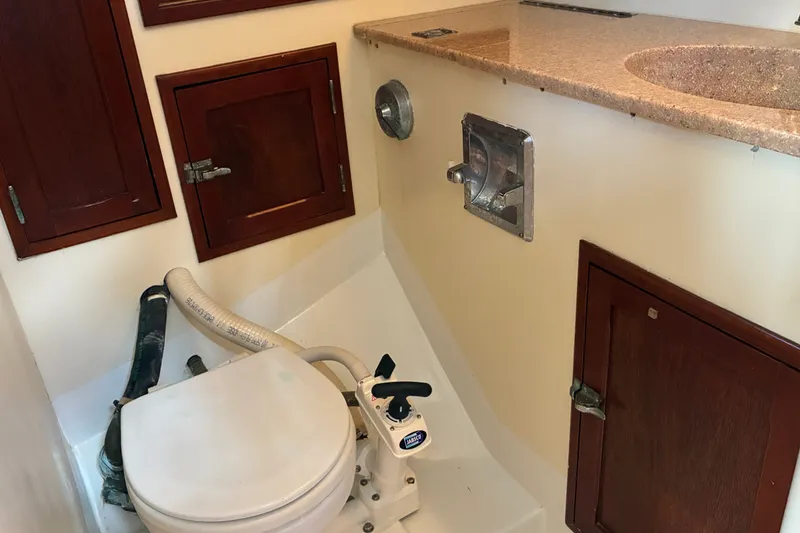Slide: The Image of Hinckley Bermuda 40 MKIII 1966 yacht bathroom with toilet, wooden cabinets, and countertop sink. - 46
