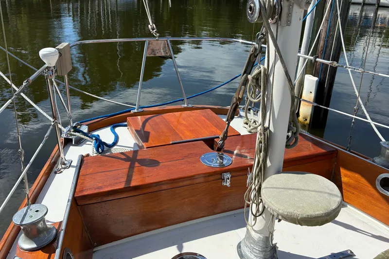 Slide: The Image of Hinckley Bermuda 40 MKIII sailboat deck, showcasing polished wood and rigging, docked in calm waters. - 14