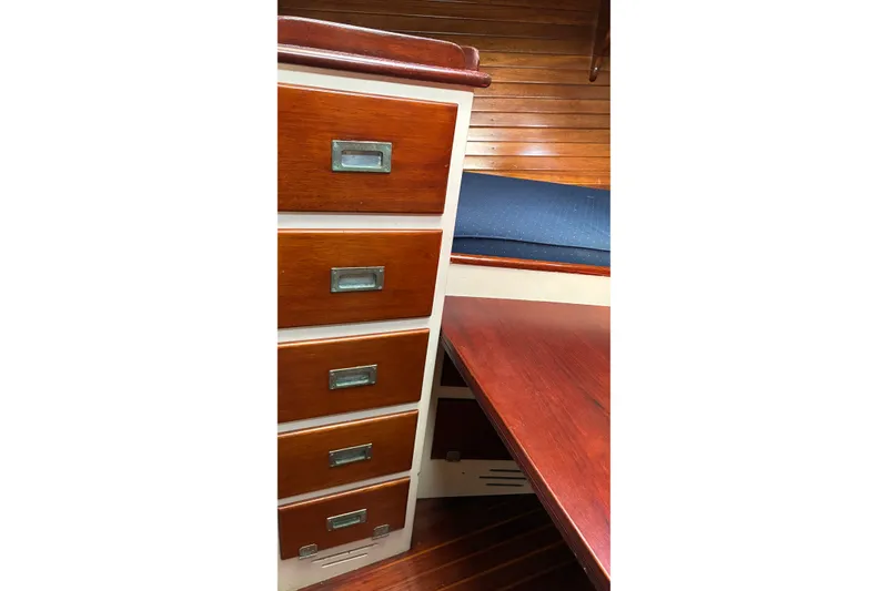 Slide: The Image of Interior of 1966 Hinckley Bermuda 40 MKIII with wooden drawers and blue cushioned seating. - 48