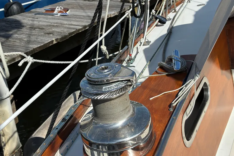 Slide: The Image of Hinckley Bermuda 40 MKIII sailboat deck with winch and ropes, docked at a wooden pier. - 19