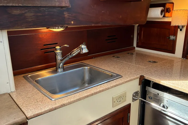 Slide: The Image of 1966 Hinckley Bermuda 40 MKIII yacht kitchen with stainless steel sink and wooden cabinetry. - 27