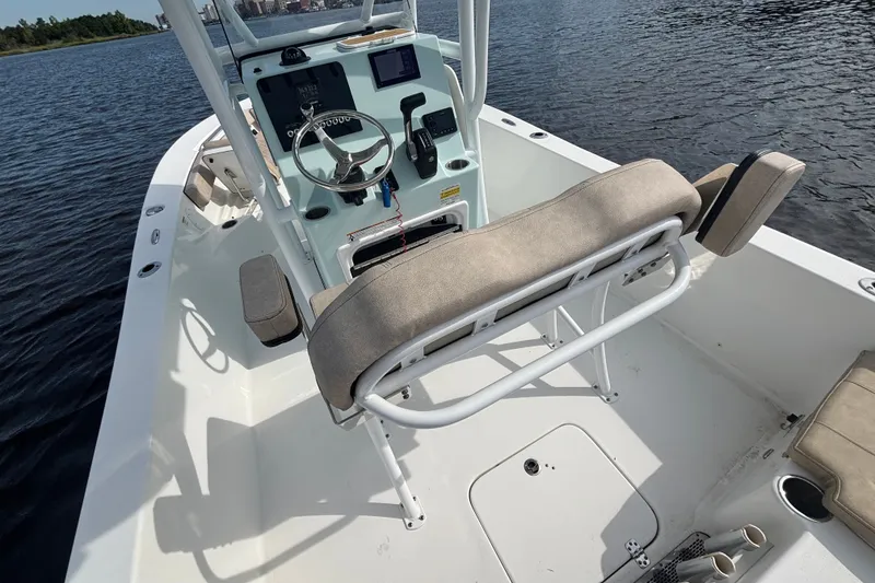 Slide: The Image of 2024 Sea Pro 202 Center Console boat interior with steering wheel and seating on water. - 14