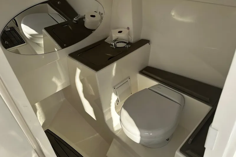 Slide: The Image of 2023 Edgewater 262CX Crossover boat bathroom with toilet, sink, and mirror. - 21