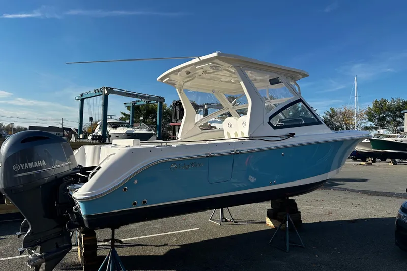 Slide: The Image of 2023 Edgewater 262CX Crossover boat with Yamaha engine, displayed outdoors on stands. - 5