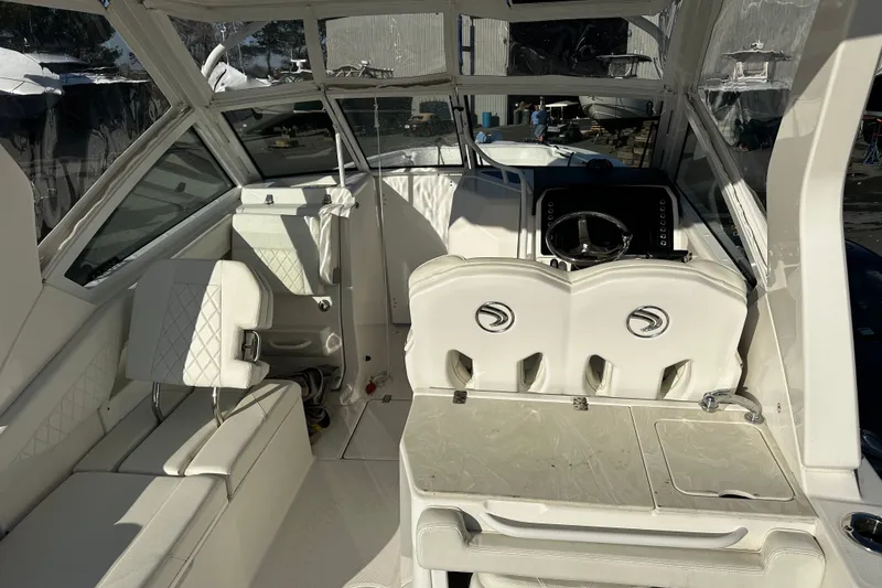 Slide: The Image of 2023 Edgewater 262CX Crossover boat interior with white seating and modern dashboard. - 9