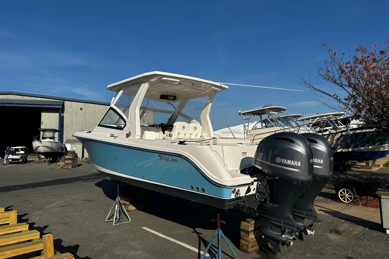 Slide: The Image of 2023 Edgewater 262CX Crossover boat with Yamaha engines in a marina setting. - 2