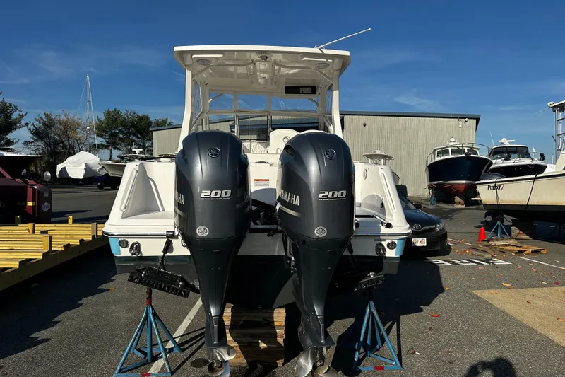 Slide: The Image of 2023 Edgewater 262CX Crossover boat with dual Yamaha 200 engines in a marina setting. - 4