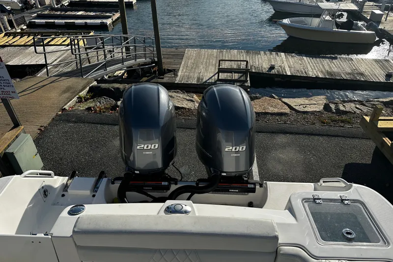 Slide: The Image of 2023 Edgewater 262CX Crossover boat with twin Yamaha 200 engines at a dock. - 6