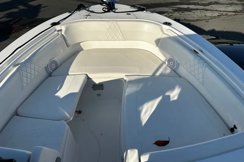 Slide: The Image of 2023 Edgewater 262CX Crossover boat interior with white cushioned seating and speakers. - 20