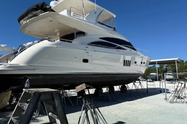 Slide: The Image of 2007 Princess 67 Flybridge Motor Yacht on stands, side view under clear blue sky. - 44