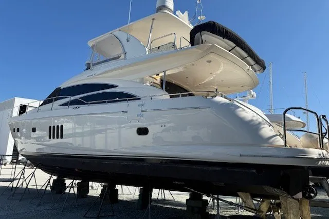 Slide: The Image of 2007 Princess 67 Flybridge Motor Yacht on stands, side view under clear blue sky. - 41