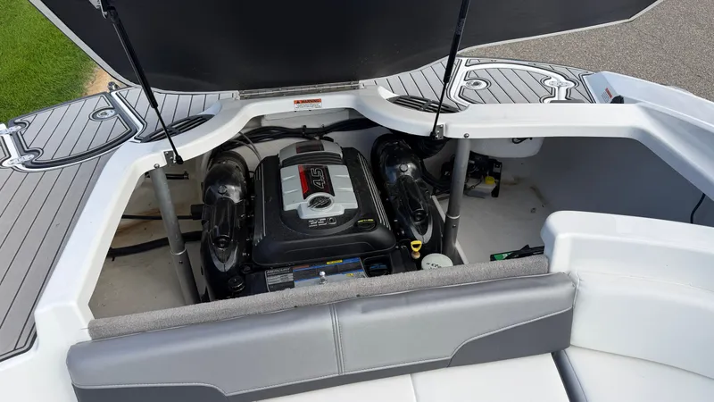 Slide: The Image of The engine compartment of a 2020 Monterey 224FS boat is open, revealing the engine. - 24