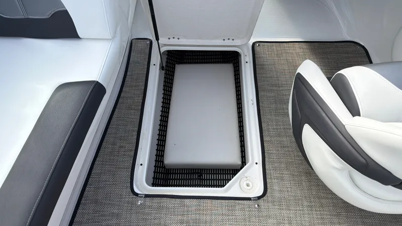 Slide: The Image of The image shows the floor area of a 2020 Monterey 224FS boat with an open storage compartment. - 49