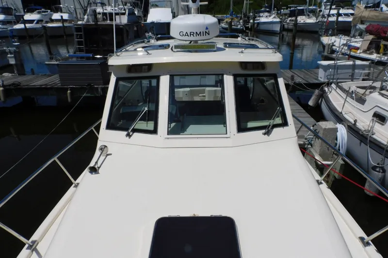 Slide: The Image of 2004 Mainship Pilot 30 Rum Runner docked at marina, featuring Garmin navigation. - 12