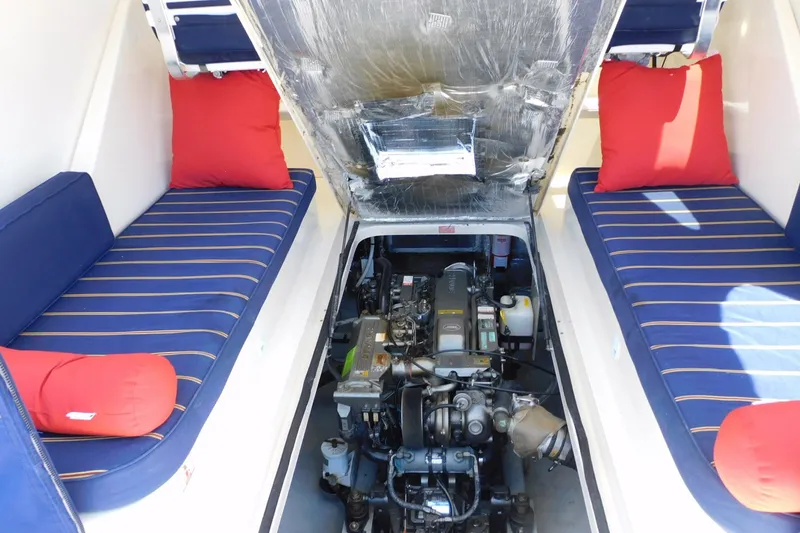 Slide: The Image of 2004 Mainship Pilot 30 Rum Runner engine compartment with blue-striped seating and red cushions. - 36