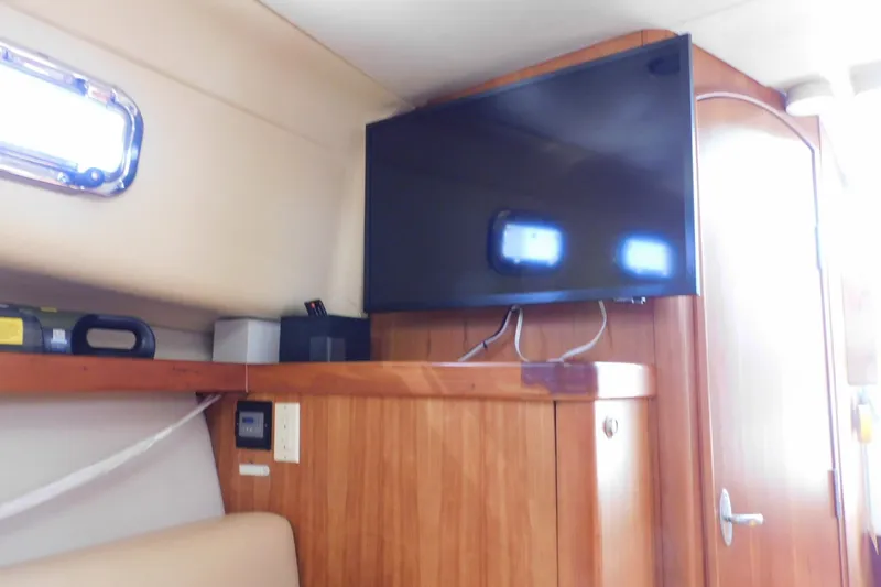 Slide: The Image of Interior of 2004 Mainship Pilot 30 Rum Runner with mounted TV and wooden cabinetry. - 32