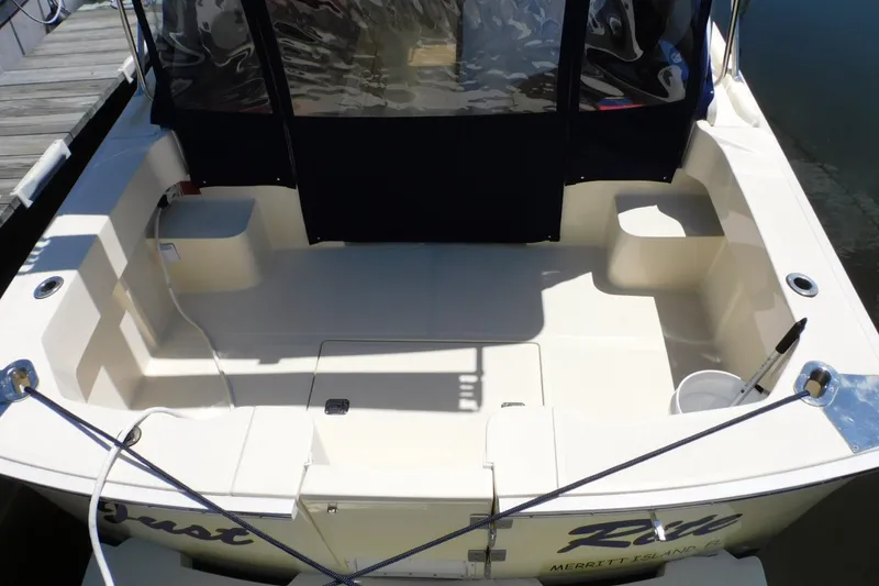 Slide: The Image of 2004 Mainship Pilot 30 Rum Runner boat cockpit with seating and dock view. - 8