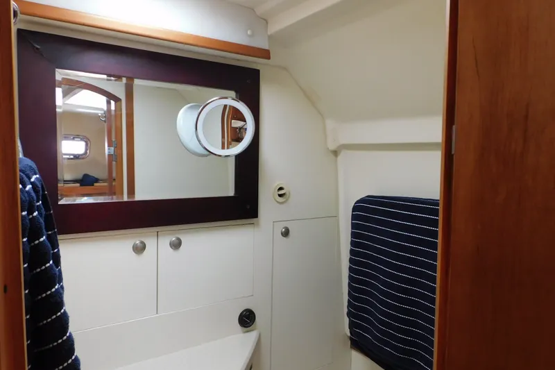 Slide: The Image of 2004 Mainship Pilot 30 Rum Runner boat interior with mirror and storage cabinets. - 30