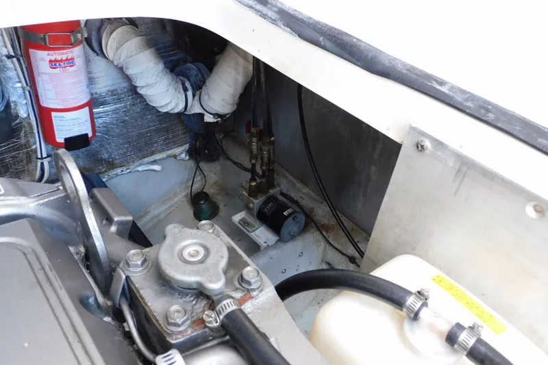 Slide: The Image of Engine compartment of a 2004 Mainship Pilot 30 Rum Runner with fire extinguisher and mechanical components. - 38