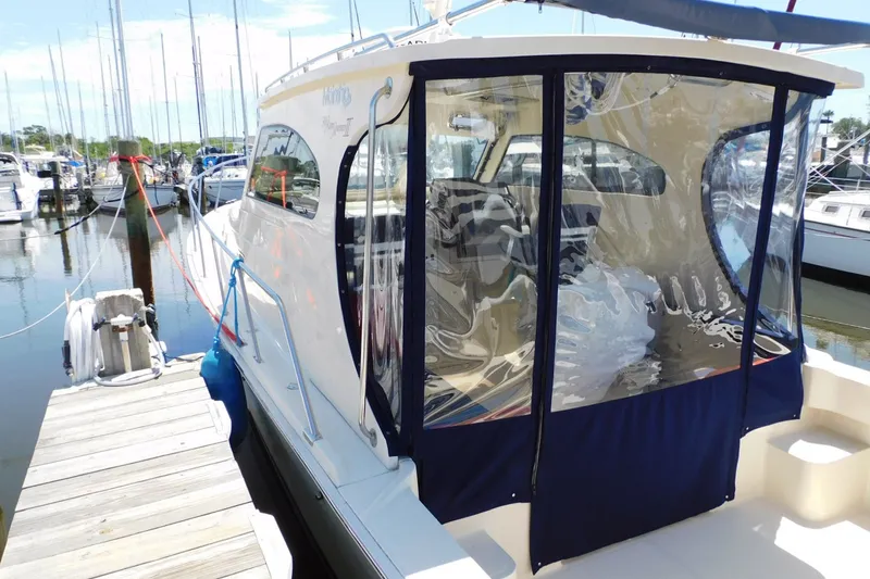 Slide: The Image of 2004 Mainship Pilot 30 Rum Runner docked at marina with clear enclosure. - 10