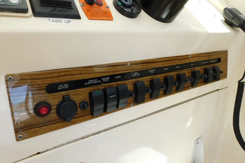 Slide: The Image of Control panel of a 2004 Mainship Pilot 30 Rum Runner boat with switches and labels. - 18