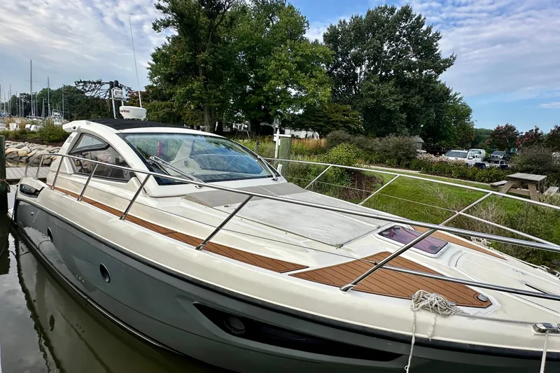 Slide: The Image of 2015 Azimut Atlantis 38 yacht docked by lush greenery and calm waters. - 3