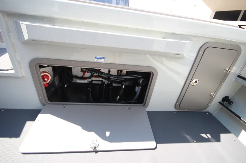 Slide: The Image of 2027 Weldcraft 240 Ocean King boat storage compartment with open hatch and visible wiring. - 16