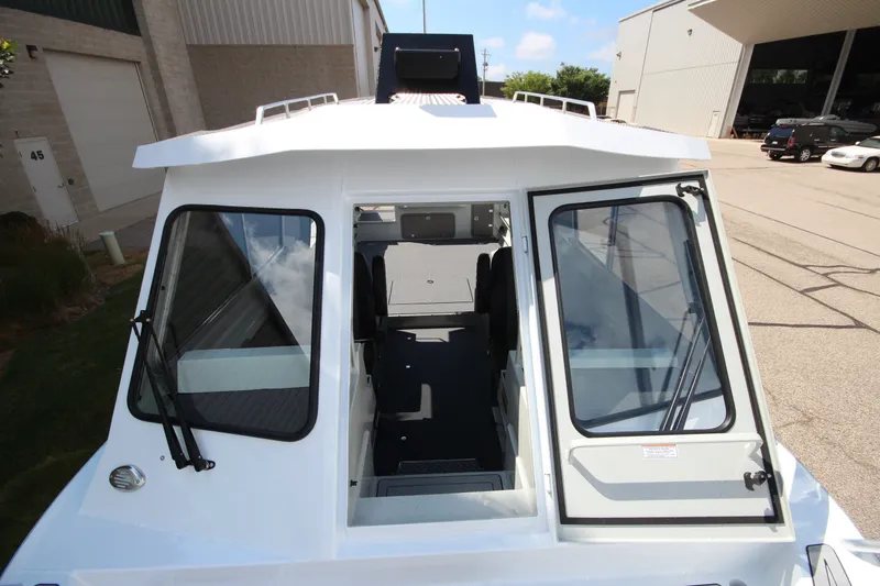 Slide: The Image of 2027 Weldcraft 240 Ocean King boat exterior with open cabin doors, parked outdoors. - 33