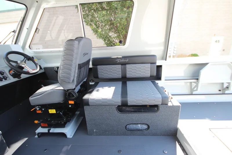 Slide: The Image of Interior of 2027 Weldcraft 240 Ocean King boat with modern seating and steering wheel. - 23