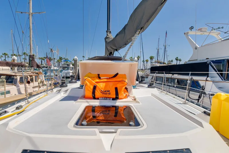 Slide: The Image of 1987 Macintosh Center Cockpit sailboat deck with orange safety bag in marina. - 45