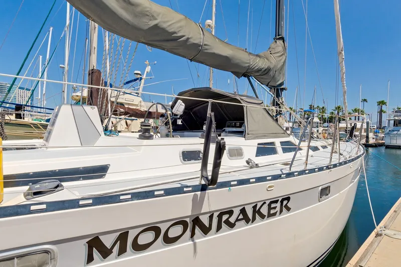 Slide: The Image of 1987 Macintosh Center Cockpit sailboat "Moonraker" docked at marina under clear blue sky. - 1
