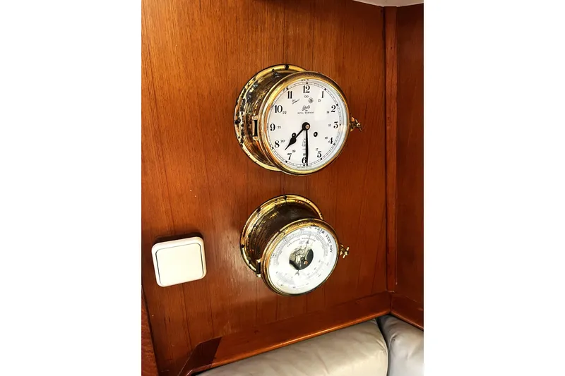 Slide: The Image of Wall-mounted clock and barometer on 1987 McIntosh Center Cockpit yacht's wooden interior. - 28