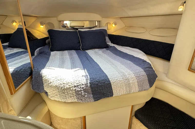 Slide: The Image of Cozy cabin interior of 2000 Sea Ray 340 Sundancer with striped bedding and soft lighting. - 16