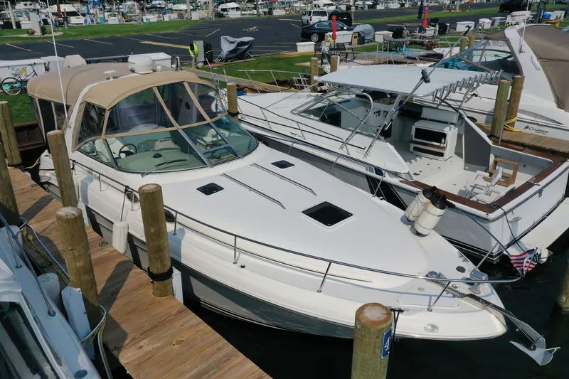 The Image of 2000 Sea Ray 340 Sundancer docked at marina, featuring sleek design and beige canopy. - 0