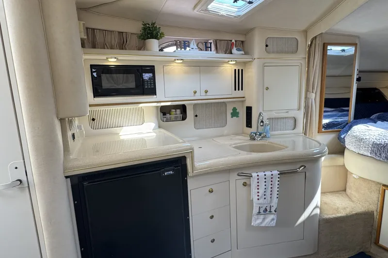 Slide: The Image of Interior of a 2000 Sea Ray 340 Sundancer yacht with kitchenette and cozy sleeping area. - 17