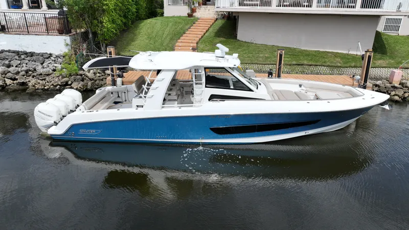 The Image of 2020 Boston Whaler 420 Outrage boat docked on calm water. - 0