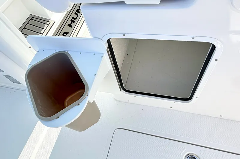 Slide: The Image of Sea Hunt Ultra 285SL 2027 boat storage compartment with open hatch and trash bin. - 16