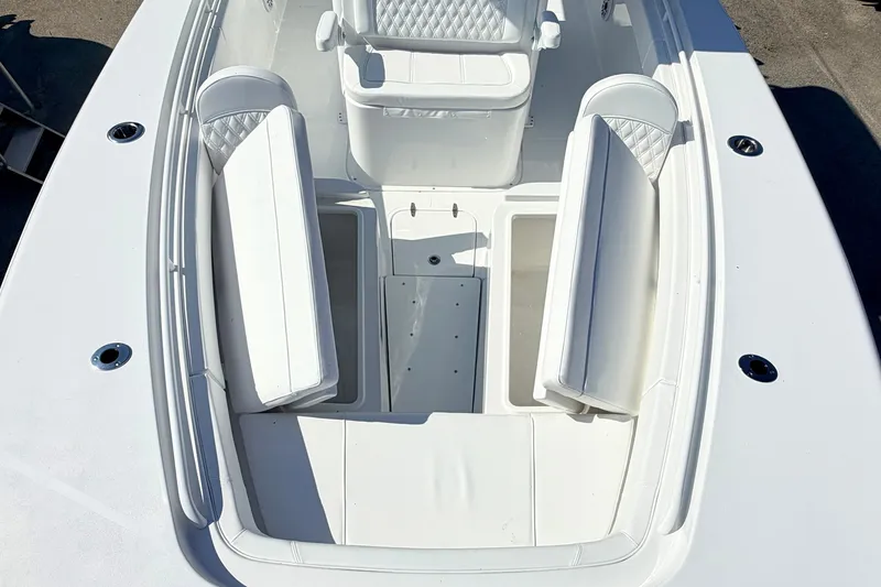 Slide: The Image of 2027 Sea Hunt Ultra 285SL boat interior with white cushioned seating and storage compartments. - 26