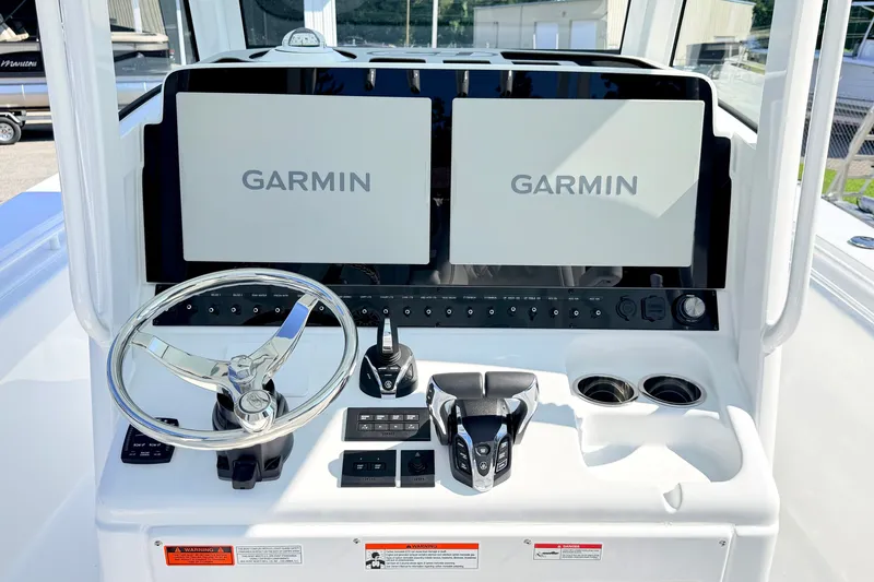 Slide: The Image of 2027 Sea Hunt Ultra 285SL boat dashboard with dual Garmin displays and steering wheel. - 19