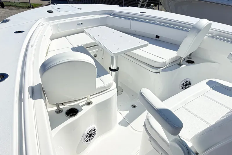 Slide: The Image of 2027 Sea Hunt Ultra 285SL boat interior with white seating and table setup. - 23