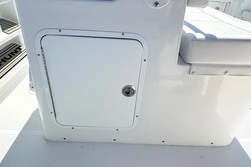 Slide: The Image of 2027 Sea Hunt Ultra 285SL boat interior storage compartment with cushioned seating. - 15