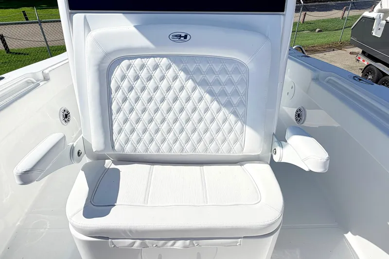 Slide: The Image of White cushioned seat on 2027 Sea Hunt Ultra 285SL boat, featuring diamond stitching and armrests. - 24