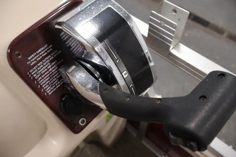 Slide: The Image of Close-up of a 2011 Sylvan Mirage 8520 boat throttle control with safety checklist. - 27