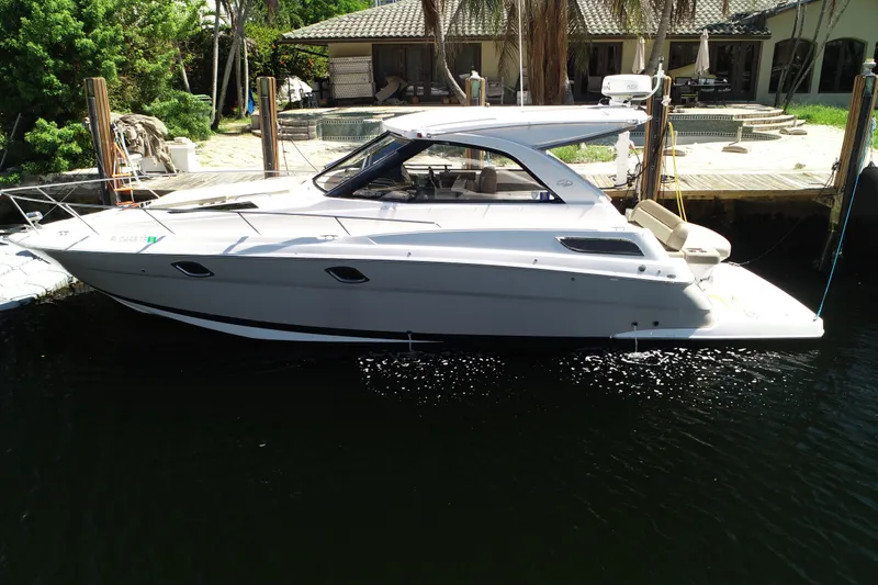 The Image of 2015 Regal 35 Sport Coupe docked by a waterfront home. - 1