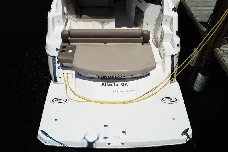Slide: The Image of 2015 Regal 35 Sport Coupe docked, rear view with seating and yellow cables. - 3