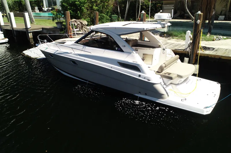 Slide: The Image of 2015 Regal 35 Sport Coupe docked in a serene marina setting. - 2