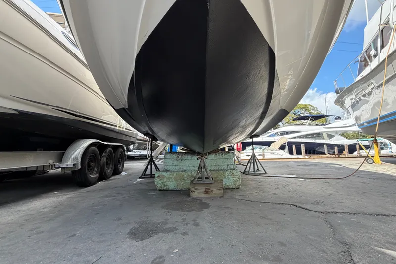 Slide: The Image of 2015 Regal 35 Sport Coupe yacht on dry dock, supported by stands, under clear blue sky. - 7